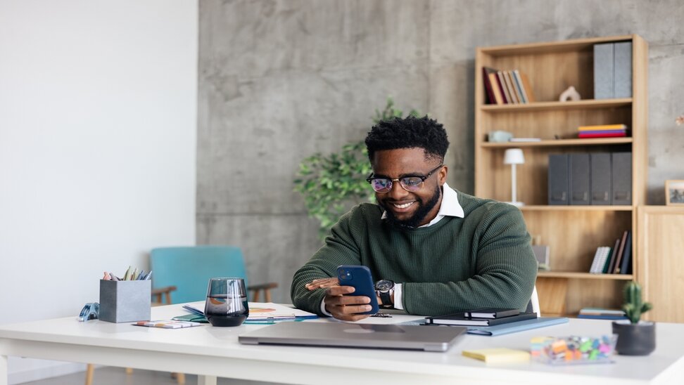 man at desk using his cellphone